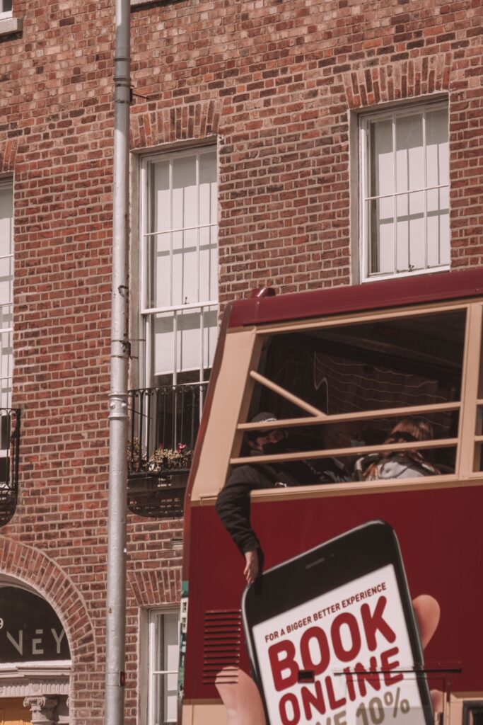 A classic Dublin bus passes by Georgian architecture in Dublin city, Ireland.