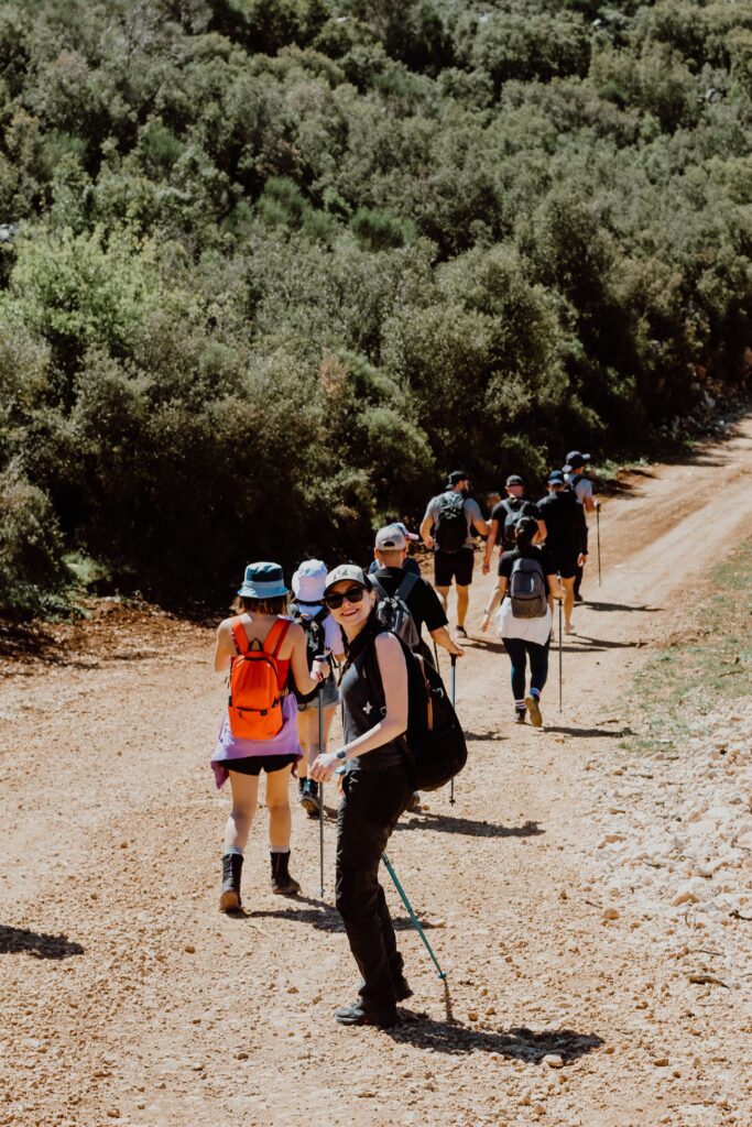 A group of hikers enjoying a sunny day on a forest trail, capturing the spirit of adventure.