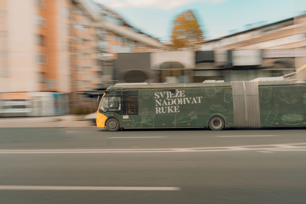 Motion blur of a moving city bus in an urban setting with dynamic speed effect.