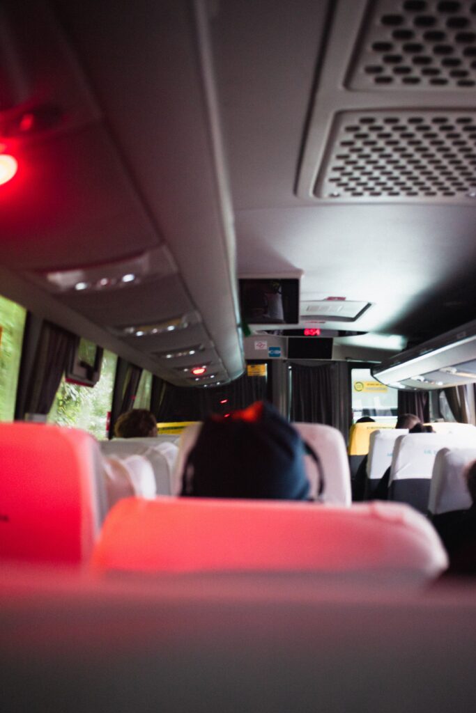 Inside view of a bus showing passengers seated with focus on interior lighting and design.